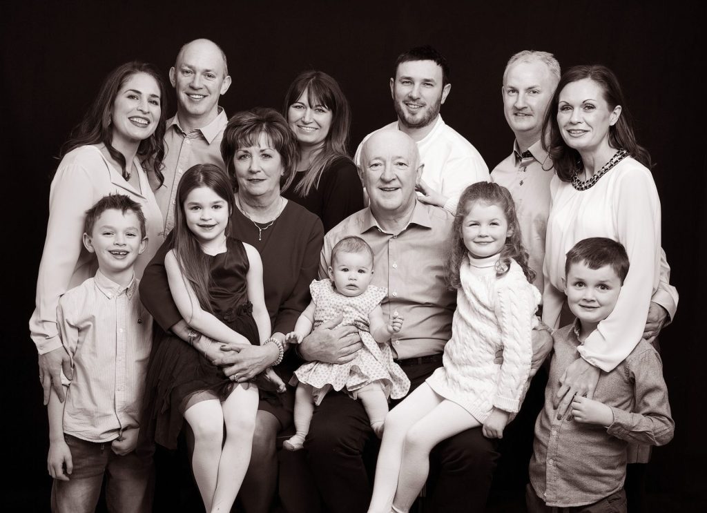 Family Photography Gift Voucher. Professional family portrait of grandparents, children and grandchildren in photography studio black and white